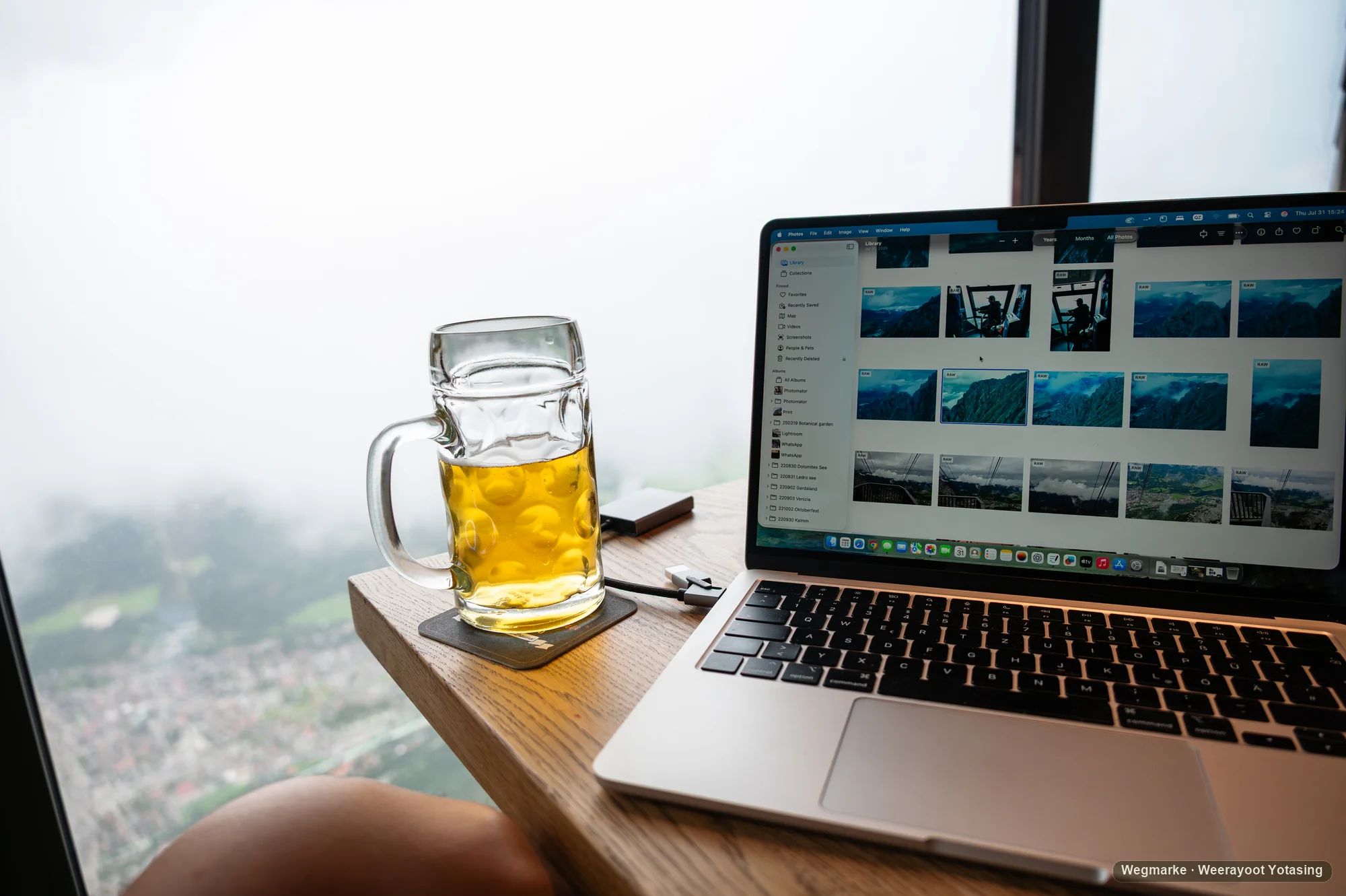 A private photo library open on a laptop beside a quiet table overlooking the valley