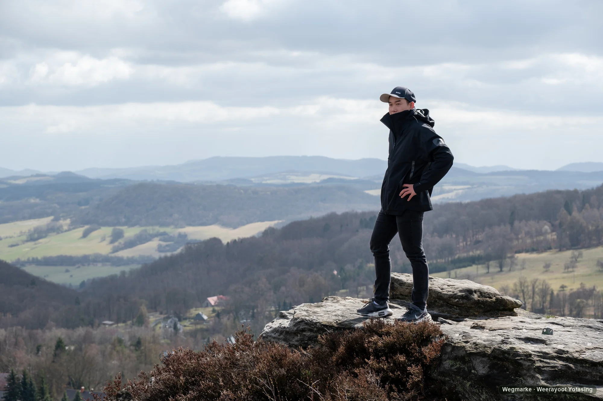 A traveler standing at the edge of a coastal cliff