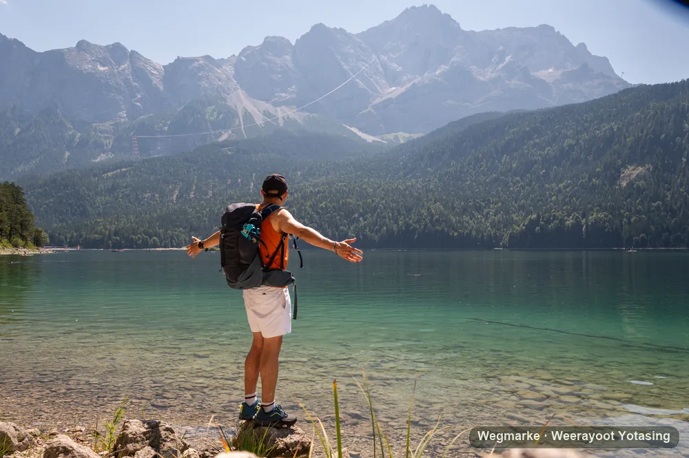 A hiker arriving at the edge of an alpine lake